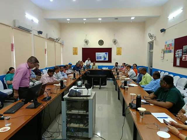Wide view of a training room with participants seated at long tables