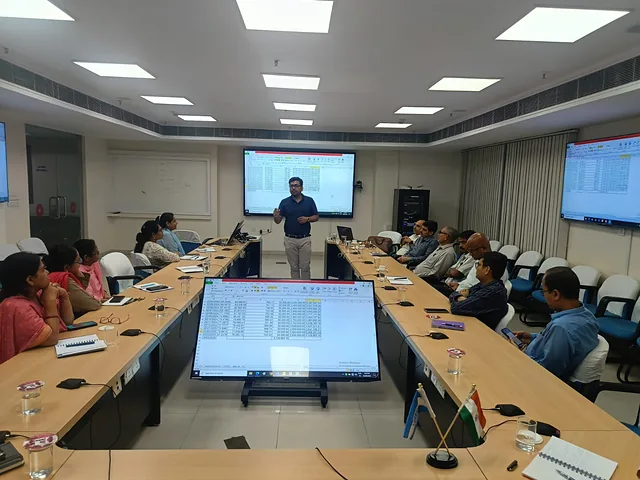 Presenter at the front of a boardroom with participants around the table