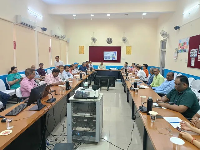 Participants seated along long tables in a training room
